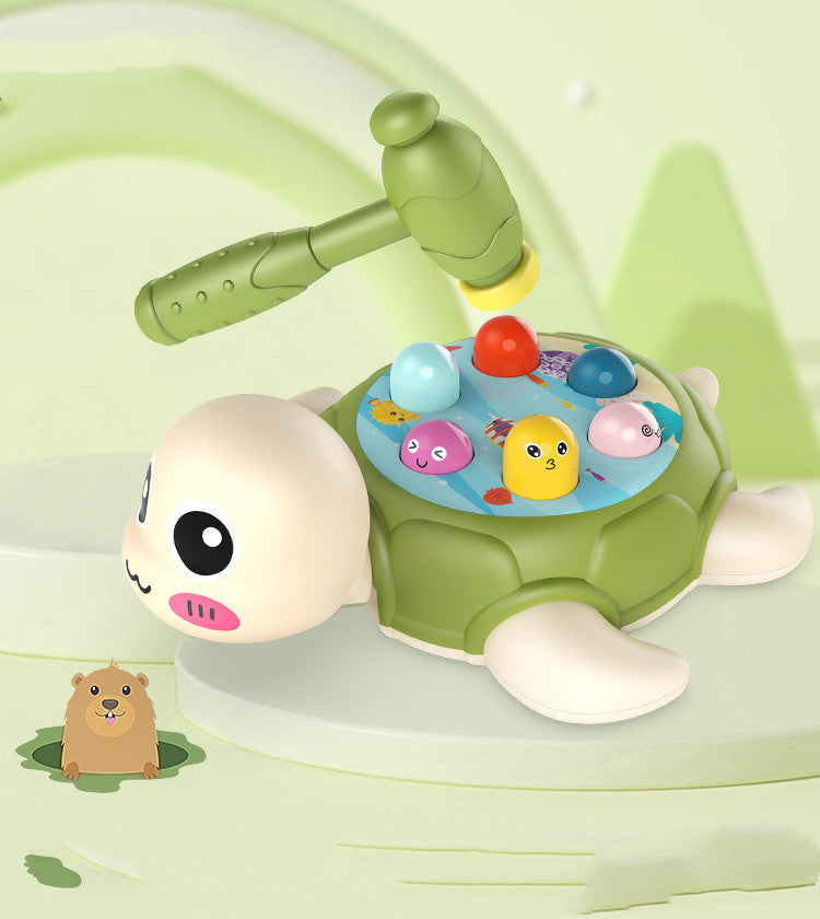 תמונת צעצוע לתינוק בצורת צב, עם 2 פטישים ומשחק "חבוט את החיה". על גב הצב יש מגוון דמויות צבעוניות המתאימות לפטיש משחק, המשמשות לפיתוח מוטוריקה עדינה וקואורדינציה לילדים בגילאי שנה ומעלה.